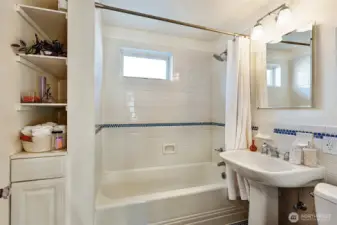 Full bathroom just down down the hall, featuring a pedestal sink & honeycomb tile work.