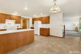 The kitchen features a U-shaped workspace plus a bank of cabinets on the opposite wall.