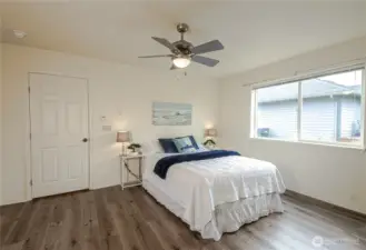 Roomy primary suite with ceiling fan and walk-in closet