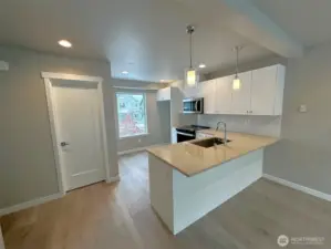 Kitchen with quartz counters and powder room to left
