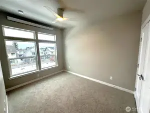 Upstairs bedroom #1 with ceiling fan and lots of nature light