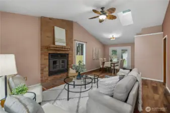 Formal living room offers a vaulted ceiling, wood burning fireplace and a ceiling fan.
