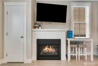 A convenient coat closet sits near the entry. The gas fireplace with shiplap surround and movable television creates a cozy setting for movie nights.