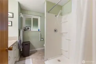 Barrier free shower with built in seat and grip bars.