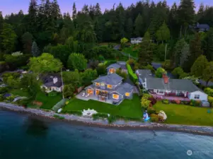Aerial view of this stunning and substantial low bank waterfront property with main house, guest house, and beautiful grounds pictured - 100' of low bank waterfront abutting sand and pebble beach.