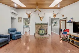 Living room with LVP flooring and wood stove with mantle that can heat the entire home.  Fan circulates heat. Mini-splits (4 total in house) for heat/AC.