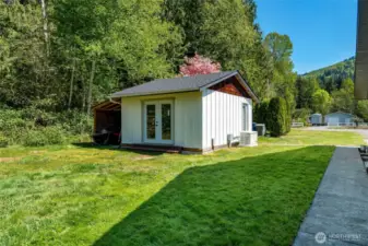 Outbuilding is 16 x 20, with power and side storage area.  Near the door is the 25KW generator that services the house during a power outage. Building is currently used as a home gym.