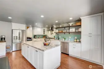 Coffee station with beverage refrigerator, SS appliances, oversized island with cabinetry on both sides, farmhouse sink, open shelving, full height backsplash, and an Italian style 8 burner range with two ovens. Let's cook!
