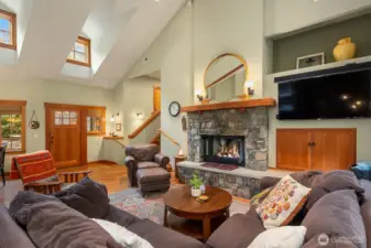 Spacious living room  with gas fireplace framed by river rock.