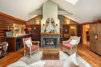 Spacious sitting room with gas fireplace and skylights, featuring wet bar.
