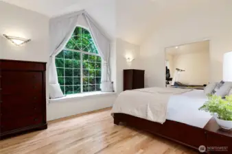Serene primary suite featuring vaulted ceilings, a charming window seat, and oversized arched window overlooking the back yard. Light-filled and spacious with a versatile attached bonus room.
