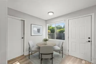 View of dining area, door on left leads to bathroom, door on right is rear door leading to yard, parking and metal storage shed