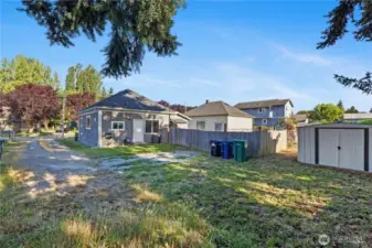 View from back of property looking towards home, fenced yard and S Baker St at end of driveway