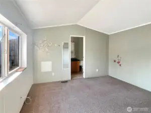 Another angle of the primary bedroom offering a view into the bathroom.