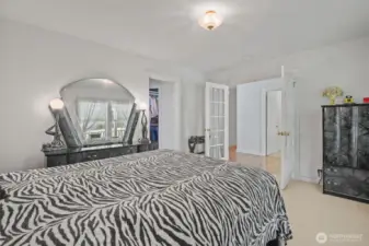 Primary bedroom with french doors, walk in closet and bath