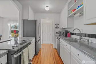 Kitchen with new appliances looking at laundry room door