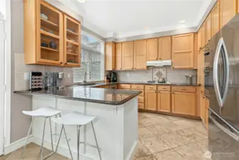 Kitchen with breakfast bar featuring slab granite countertops & Newer Refrigerator