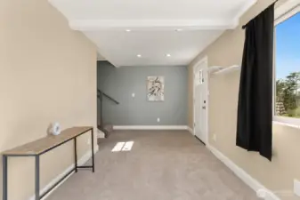 Spacious and sunlit lower-level entry with plush carpet, recessed lighting, and easy access to the patio.