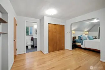 A wonderful primary suite located on the upper level is filled with classic charm and a framed archway into the bedroom area.