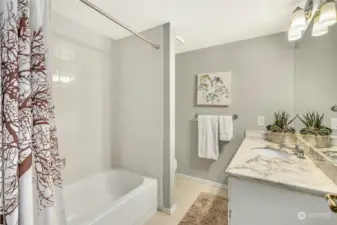 Lower level full bath with marble vanity.