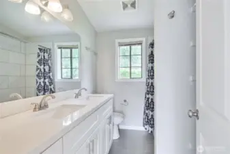 Primary bathroom. Love the quartz counters, shaker cabinets and tile floors. LOVELY.