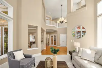 Vaulted ceilings are a key architectural feature of the home. Tall windows flood the space with natural light, open architectural niches allow for easy flow between and sightlines between living and dining rooms.