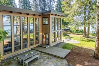 The water side of the home shows off the beautiful floor to ceiling windows and the grounds are exceptional