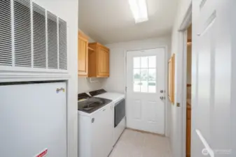 Laundry with 1/2 bath which has a large utility sink, and patio/backyard access.