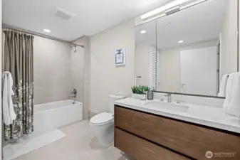 Spacious full bath with cabinet in the mirror and floating shelves vanity.