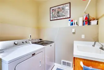 Laundry area just off the kitchen, utility sink and Maytag washer and dryer.