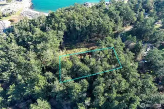 Elevated drone view showing the lot boundaries and proximity to the shoreline, illustrating the peaceful coastal setting of this Cape San Juan homesite.