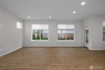 Expansive living space with large windows overlooking the backyard, creating a bright and inviting atmosphere.