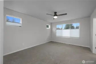 Spacious primary suite with large windows, soft natural light, and a comfortable, private feel.