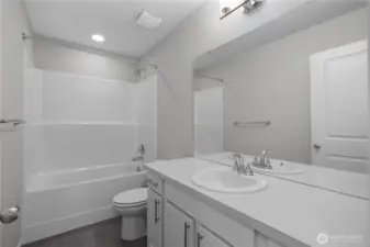 Hall Bath Full - Clean, modern bath with large mirror and sleek fixtures.