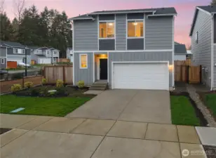 Inviting front entry with landscaped yard and driveway parking.