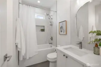 Shared bathroom in between the 2nd and 3rd bedrooms. Ceiling-height titled bath and shower, with a shower niche. Ceiling-height tile backsplash above both of the vanities.