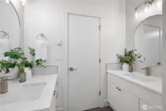 Two vanities, two sinks, tile floor, quartz counters.