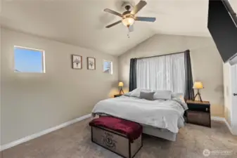 Primary bedroom with ensuite bath features vaulted ceilings.  Tv to stay with the home