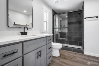 Brand new Primary bathroom: vanity, counter, mirror, toilet, hardware. Custom tiled walk-in shower with glass door.