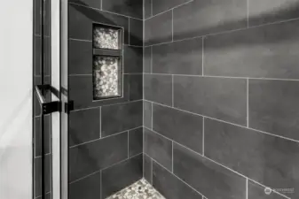 Ahh... luxury! Custom tiled shower with inserts for your soaps and shampoo. Check out the pebbled flooring.