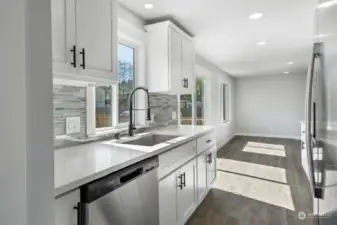 Delightful galley-style Kitchen where everything is new! Crisp white shaker-style cabientry with new hardware, quartz counters. Stainless appliances.