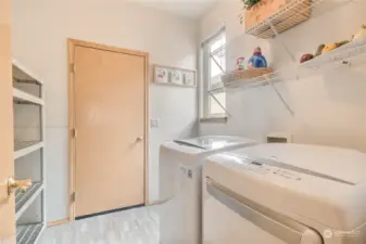 Large laundry room with space for shelving plus a window & it's plumbed for a utility sink. The door leads out to the 2 car garage.