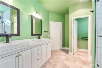 Remodeled primary bathroom with dual sink vanities, LVP flooring, private commode room, big shower & large walk-in closet