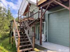 Private exterior entrance to upper level ADU guest studio. Brand new decking. Lower access to interior stairway to upper studio and laundry as well as a second doorway to the 2 car garage and large RV bay.