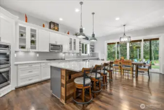 Barnwood decor on massive island and the huge sliding doors to the back are just a few of the details the home offers. Beautifully detailed hanging lights over the island offer the perfect ambiance.