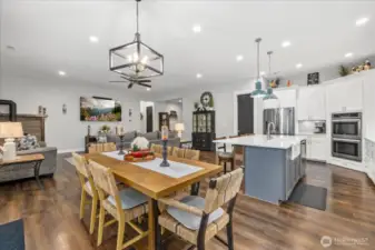 Large dining area open to living area and separate coffee bar to the right with custom shelves.
