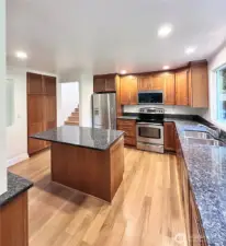 The open-concept living area boasts a statement fireplace and a chef’s dream kitchen with granite countertops, SS appliances, and an island with even more storage.