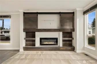 Stylish built-in fireplace wall features custom shelving with sliding barn doors, creating a warm focal point with both character and functionality.