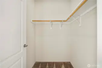 Spacious walk-in closet offers built-in shelving and ample storage for an organized primary suite.