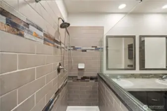 Alternate view highlights the custom tiled shower w/glass half-wall design and modern finishes throughout the bathroom.